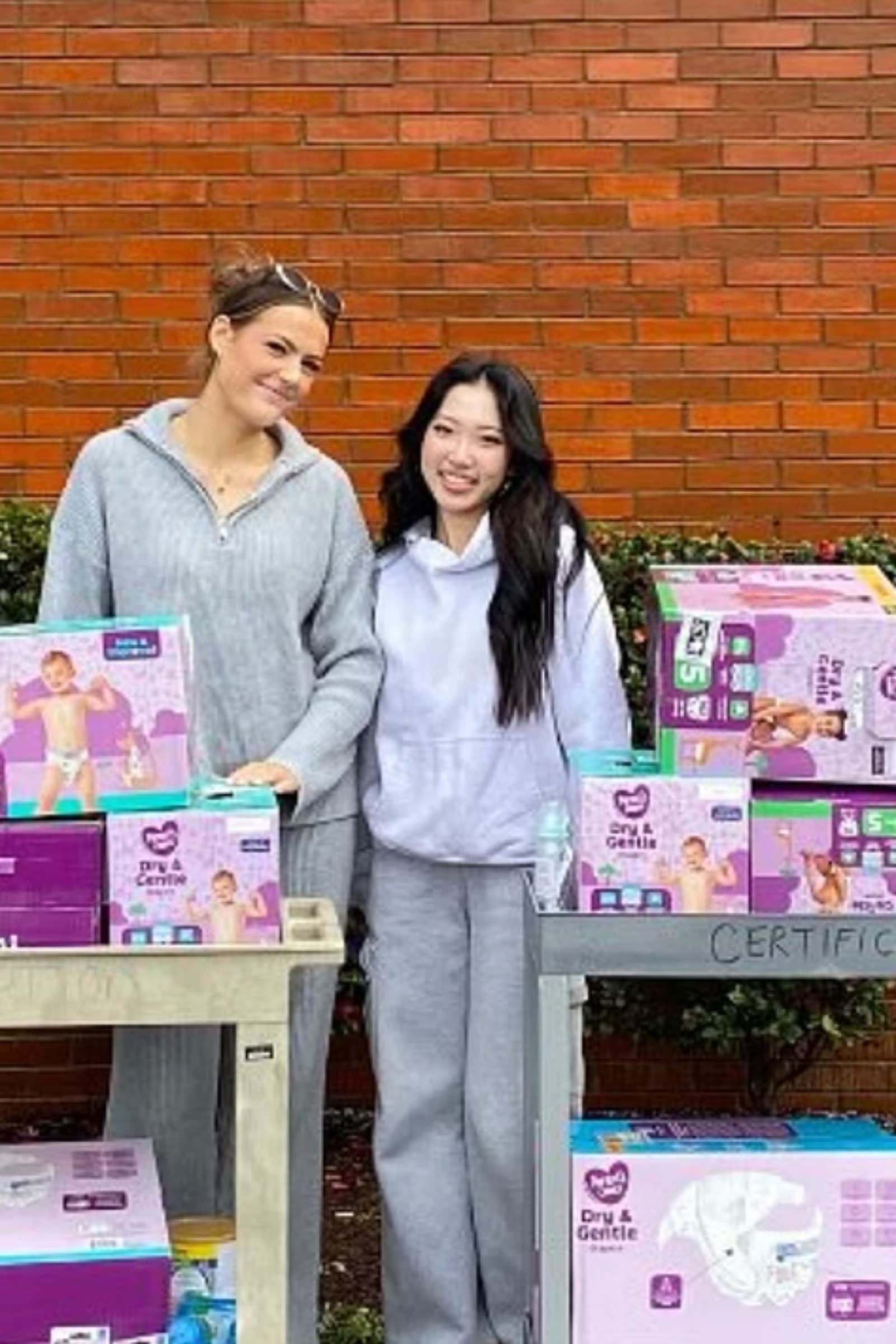 AIQ volunteers with tables of donated necessities at a drive